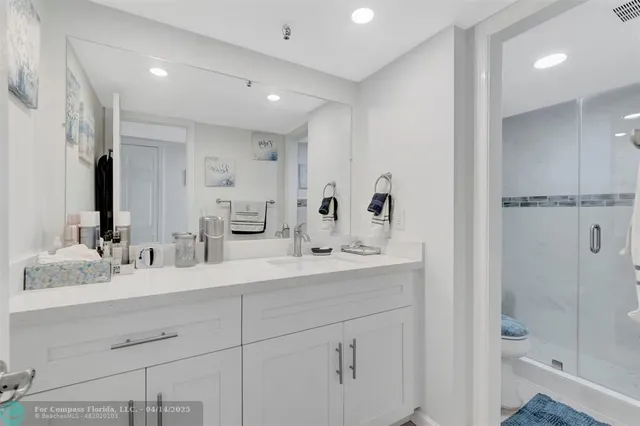 a bathroom with a double vanity sink toilet mirror and shower