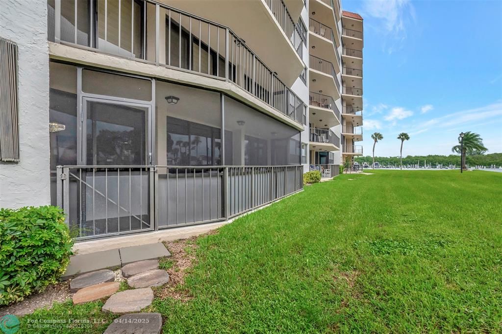 899 Jeffery Street, Unit 109 Boca Raton, FL 33487 - Photo 25 of 37 a backyard of a building with lawn chairs and a yard