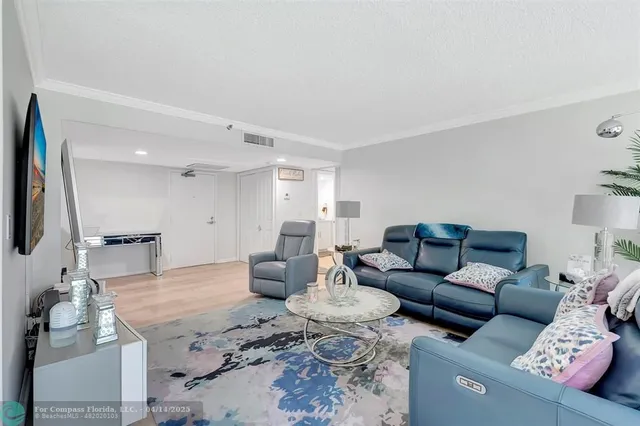 a living room with furniture wooden floor and a flat screen tv