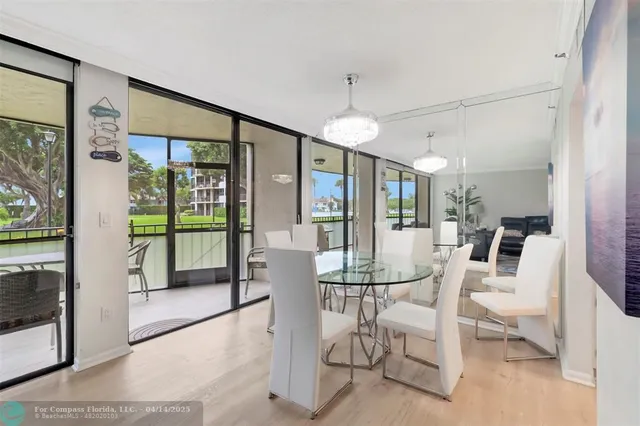 a dining room with furniture a chandelier and glass door