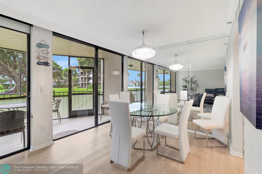 899 Jeffery Street, Unit 109 Boca Raton, FL 33487 - Photo 9 of 37 a dining room with furniture a chandelier and glass door