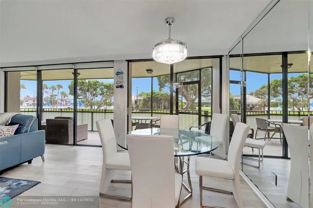 a view of a dining room with furniture large windows and a chandelier