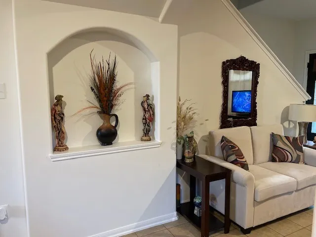 a living room with furniture and a painting on the wall