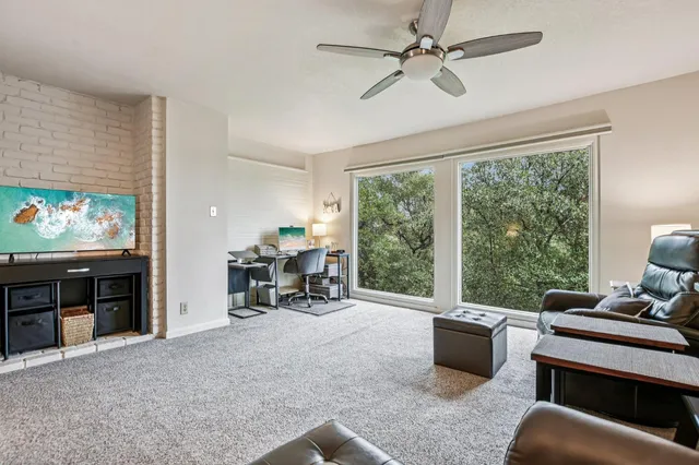 a backyard of a house with table chairs and wooden fence