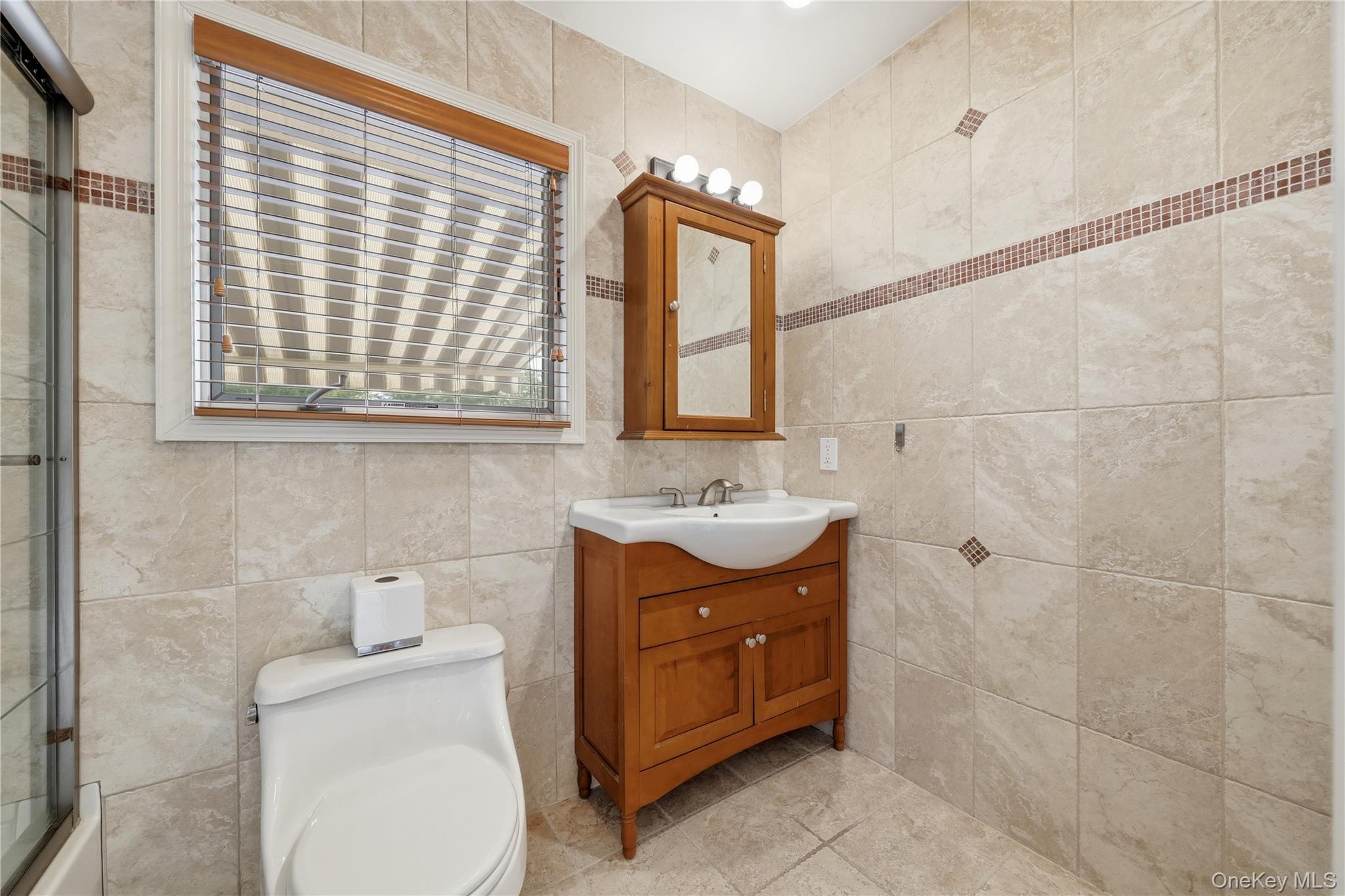 1853 Decatur Avenue Merrick, NY 11566 - Photo 28 of 43 a bathroom with a sink toilet and mirror