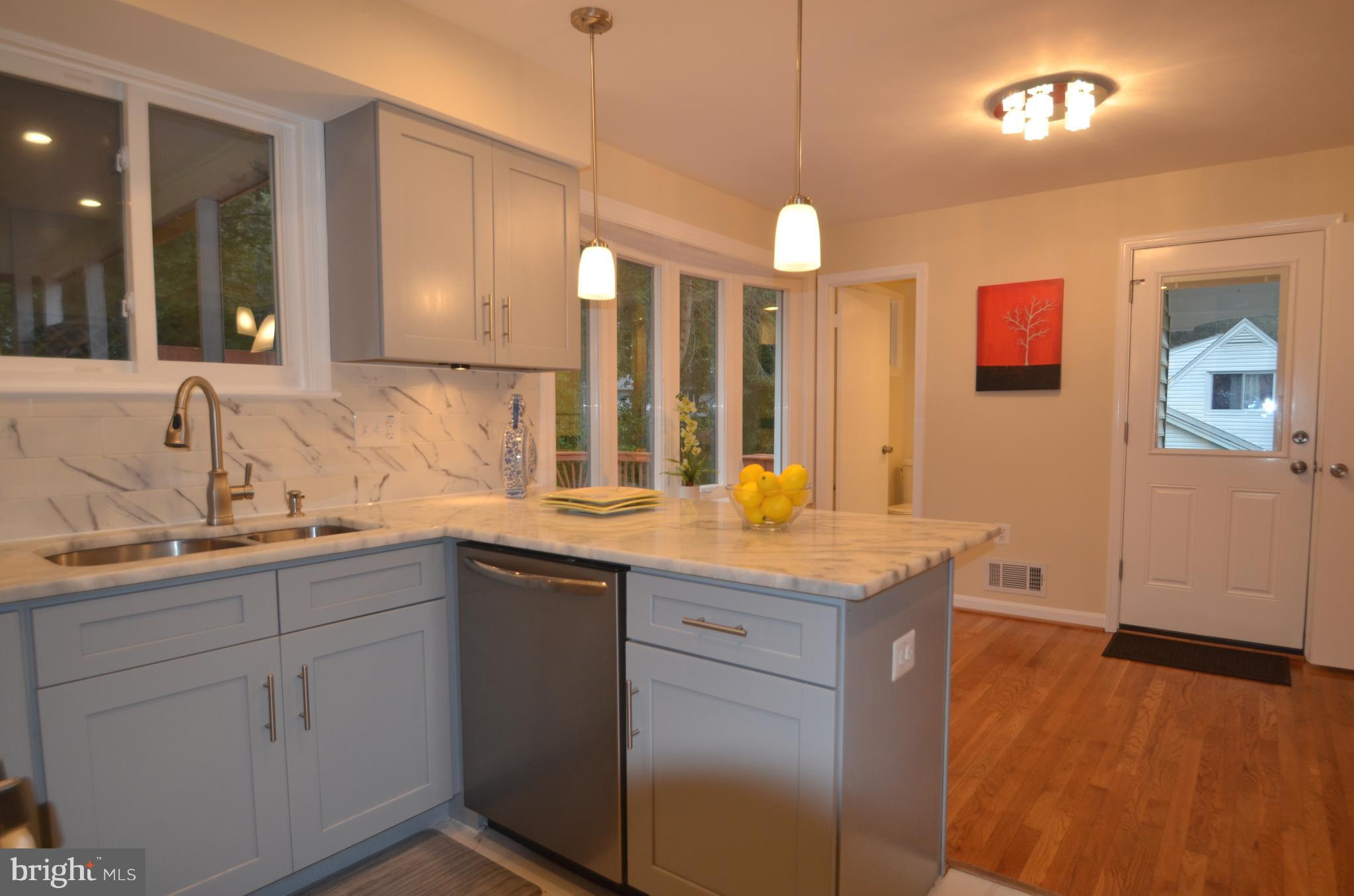 8627 Victoria Road Springfield, VA 22151 - Photo 12 of 30 a kitchen with a sink dishwasher and a stove with wooden floor