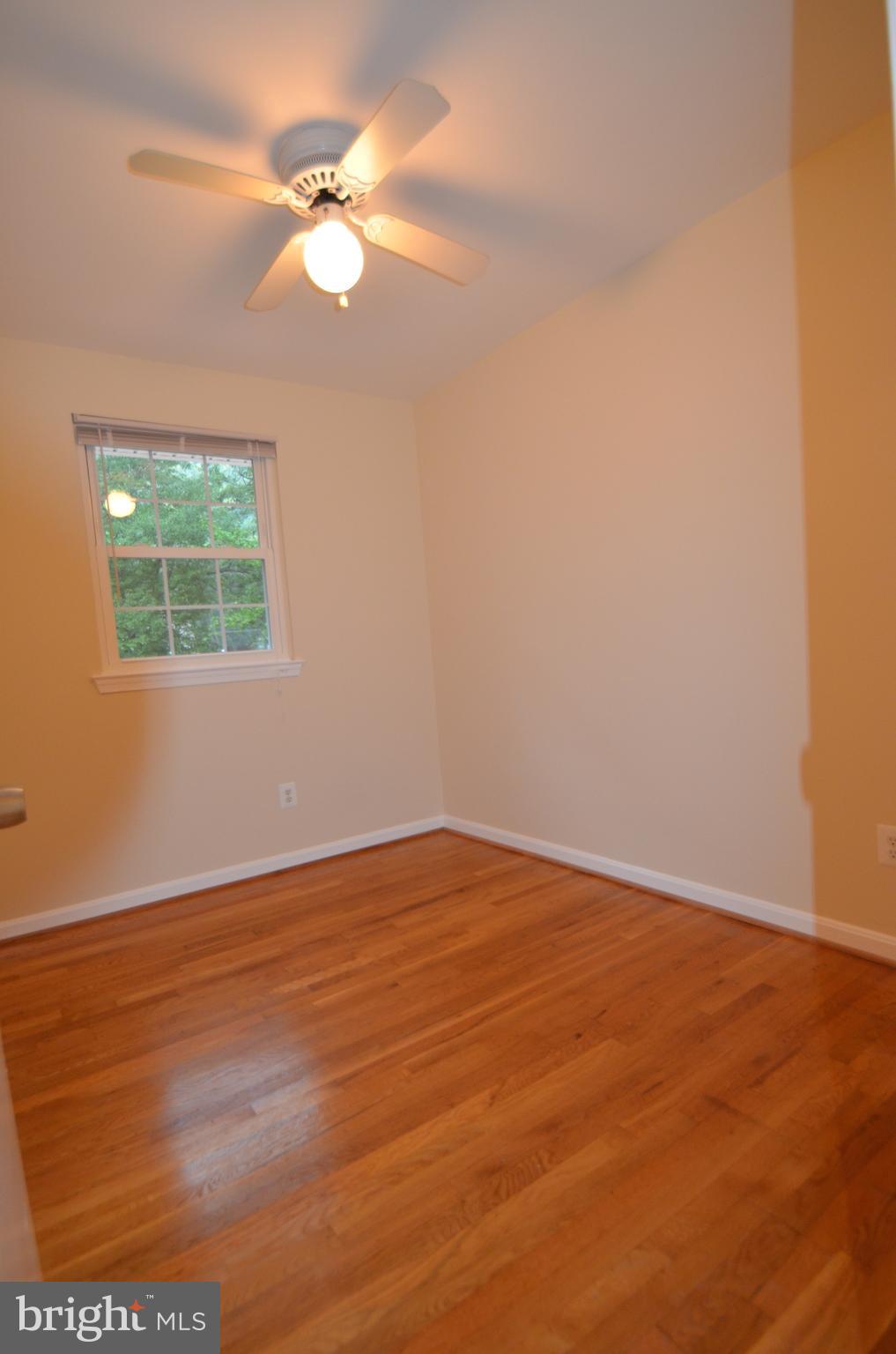 8627 Victoria Road Springfield, VA 22151 - Photo 19 of 30 an empty room with wooden floor fan and windows