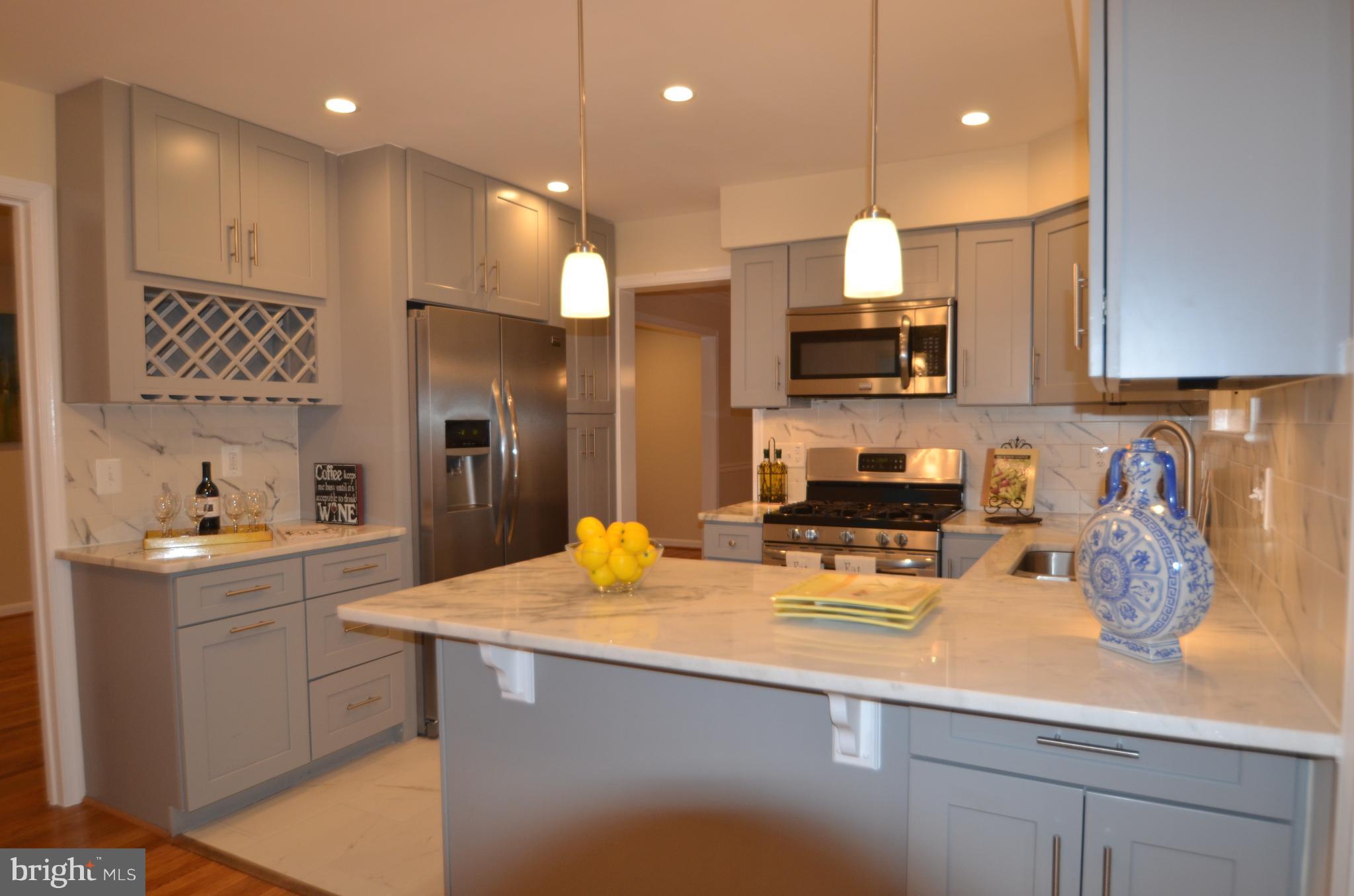 8627 Victoria Road Springfield, VA 22151 - Photo 8 of 30 a kitchen with a sink a stove and chairs