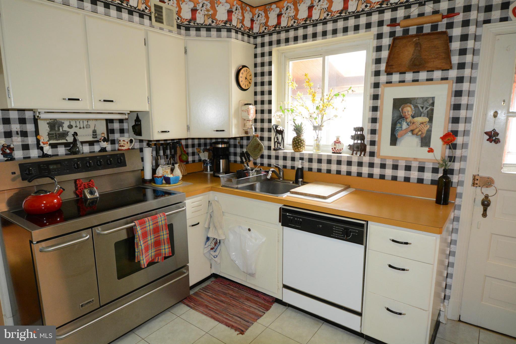8605 Springdell Place Chevy Chase, MD 20815 - Photo 3 of 15 a kitchen with stainless steel appliances white cabinets and a stove