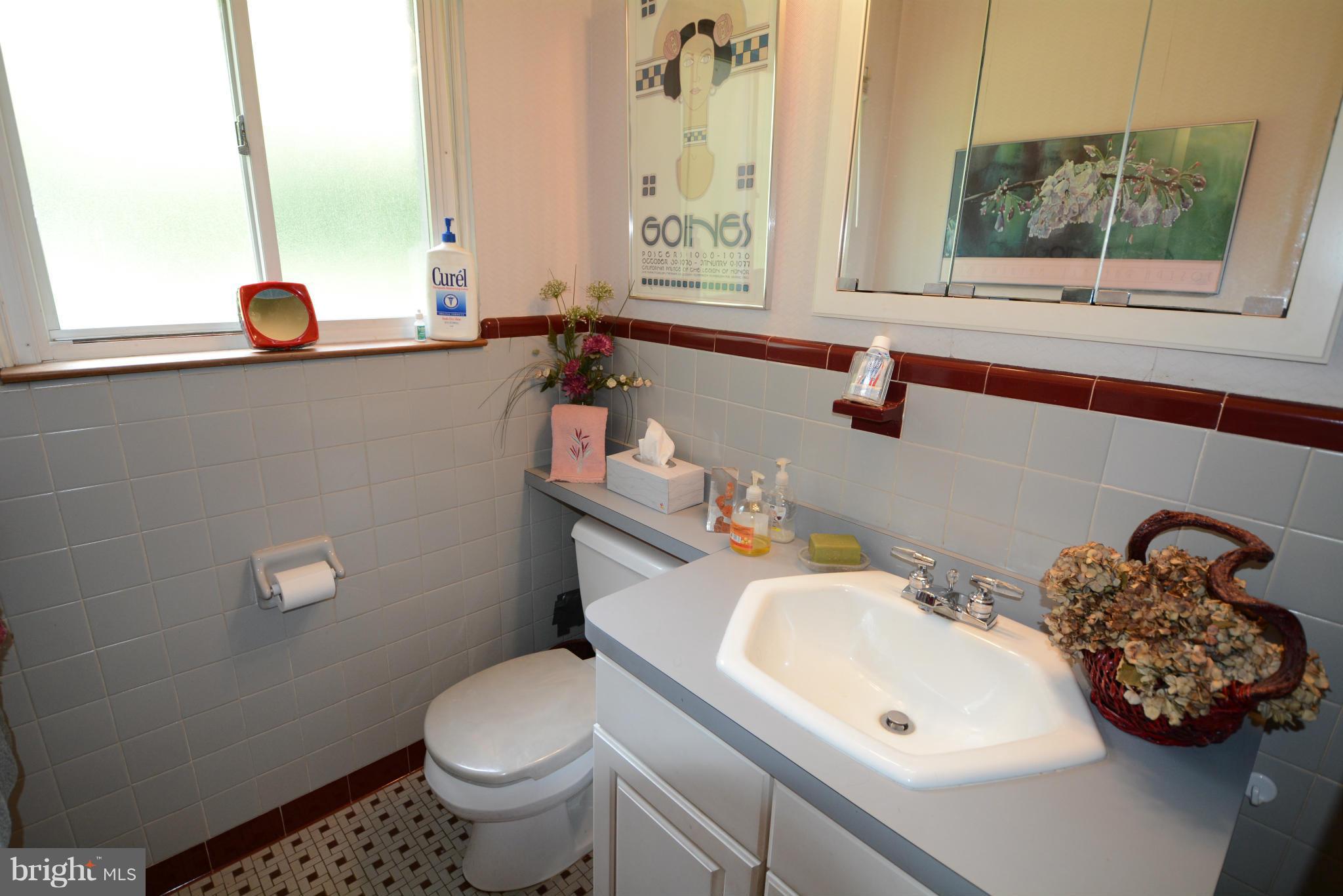 8605 Springdell Place Chevy Chase, MD 20815 - Photo 7 of 15 a bathroom with a sink a toilet and a mirror