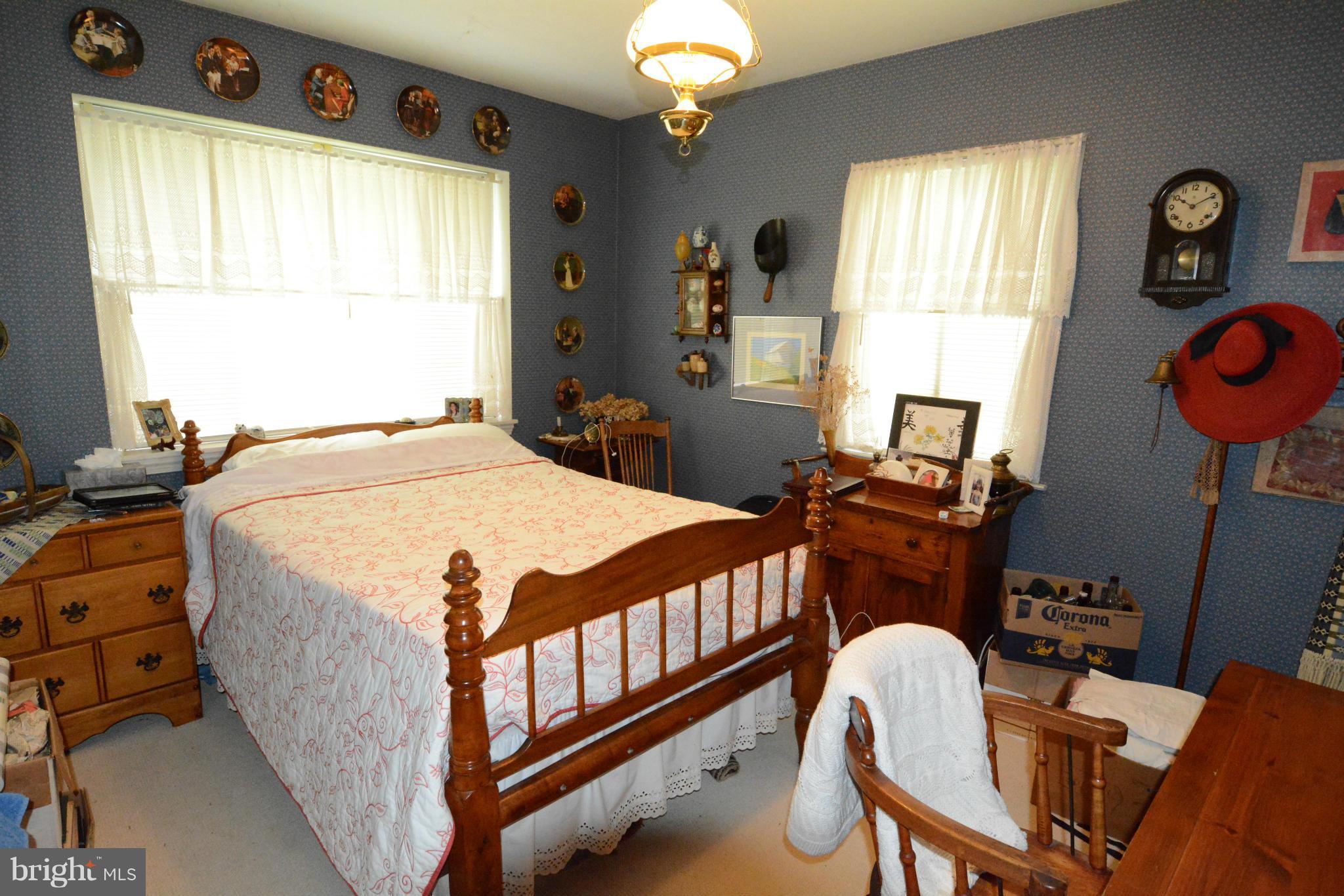 8605 Springdell Place Chevy Chase, MD 20815 - Photo 9 of 15 a bedroom with wooden bed a window and a chandelier