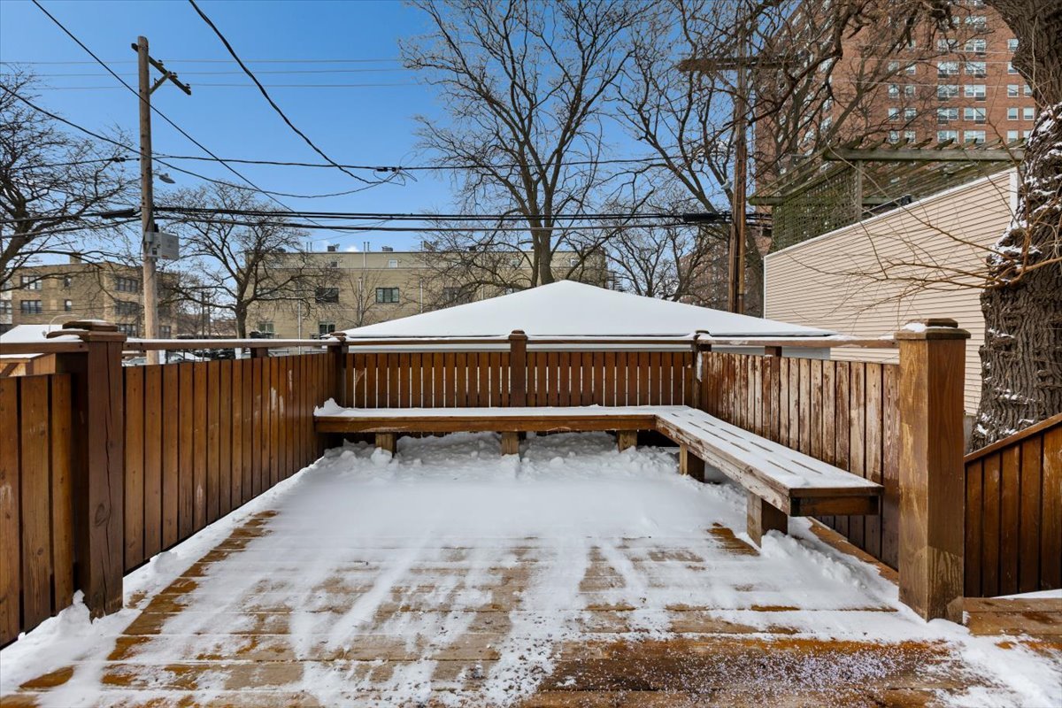 1328 West Byron Street Chicago, IL 60613 - Photo 34 of 40 a view of a backyard with wooden fence and a roof