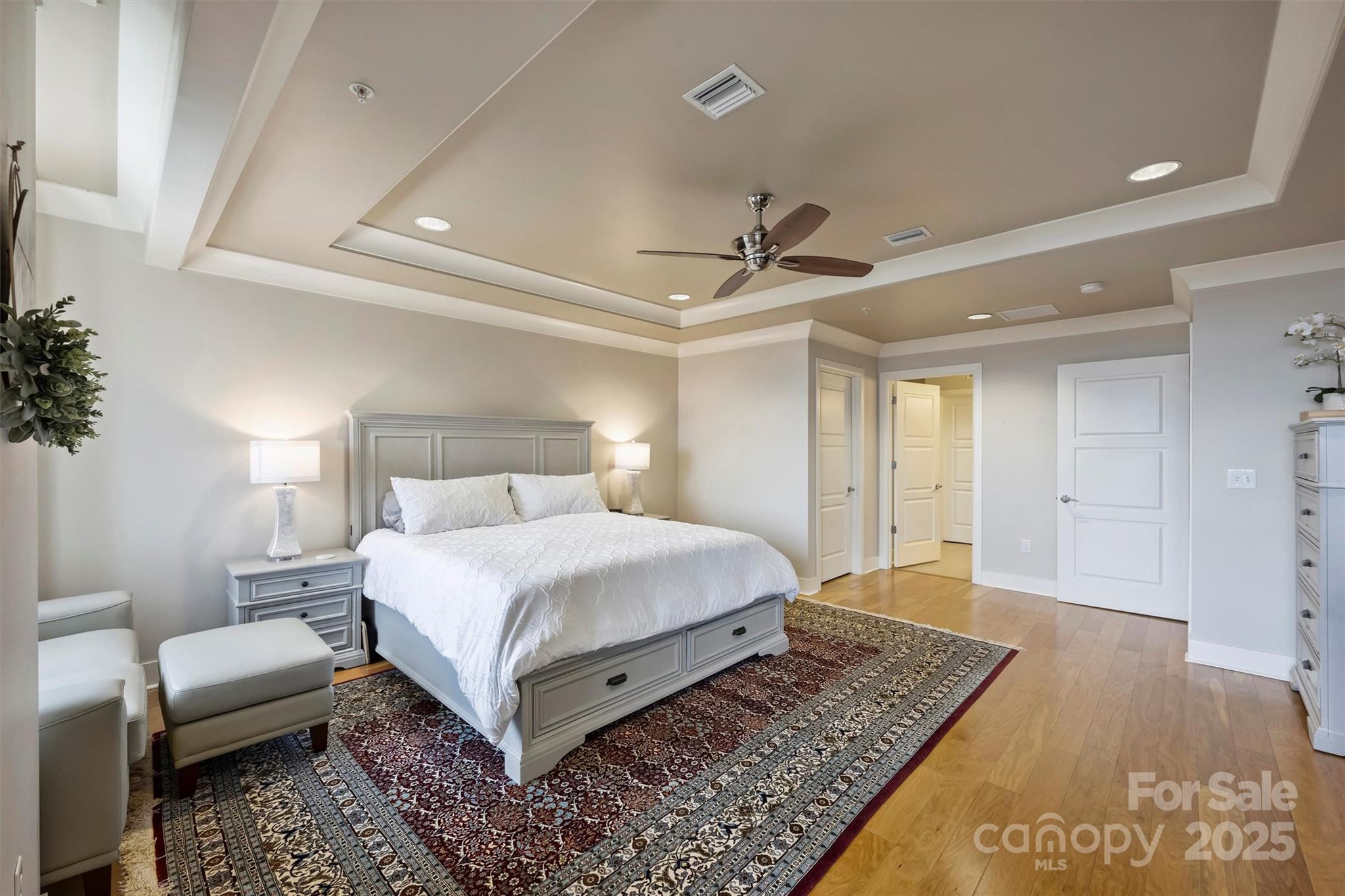222 South Caldwell Street, Unit 1812 Charlotte, NC 28202 - Photo 22 of 37 a bedroom with a bed a couch and potted plant with the view of bathroom