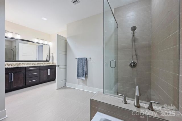 a spacious bathroom with a granite countertop sink mirror and shower