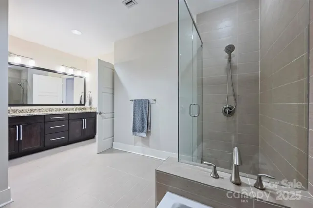 a spacious bathroom with a granite countertop sink mirror and shower