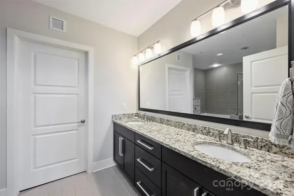 a bathroom with a granite countertop sink and a mirror