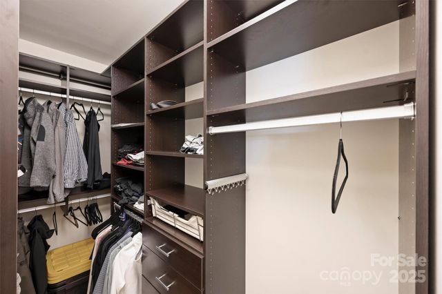 a view of walk in closet with clothes
