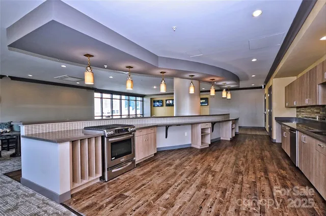 a kitchen with stainless steel appliances granite countertop a stove and a wooden floors