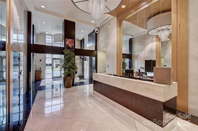 a large white kitchen with a counter top space and stainless steel appliances