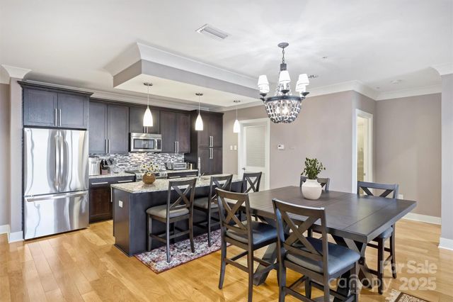 a view of a dining room with furniture a chandelier and wooden floor