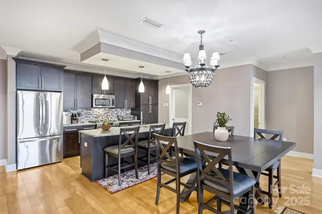 a view of a dining room with furniture a chandelier and wooden floor