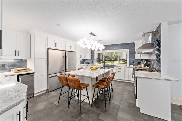 a dining room with stainless steel appliances granite countertop a dining table and chairs