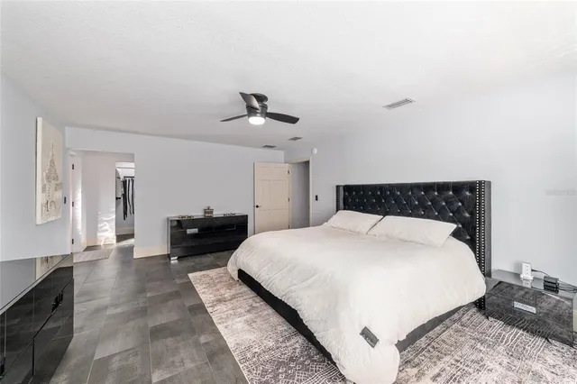 a large bed sitting in a bedroom and chair