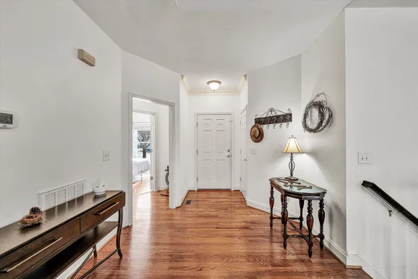 a view of hallway with furniture and wooden floor