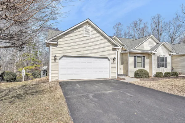 a front view of a house with a garden and yard