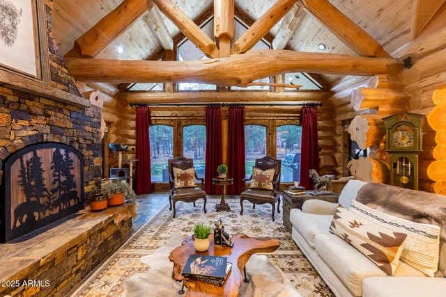 a living room with furniture a fireplace and large windows