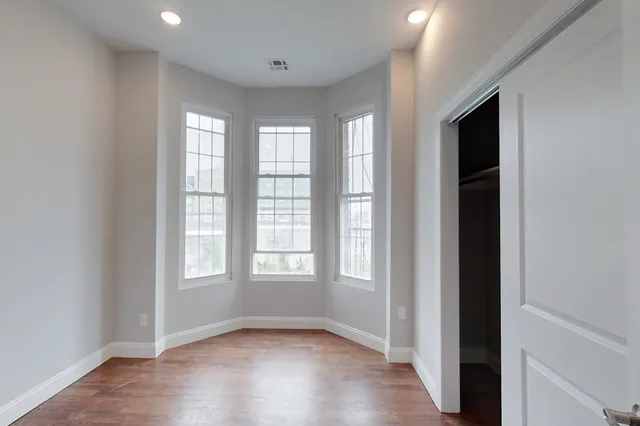 an empty room with windows and closet