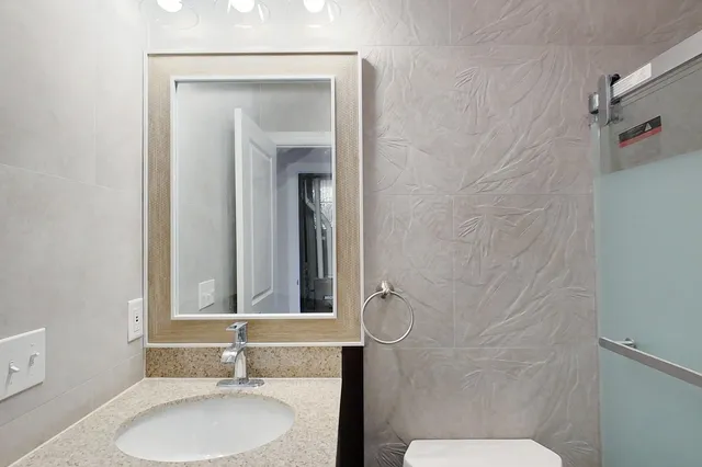 a bathroom with a sink toilet and mirror