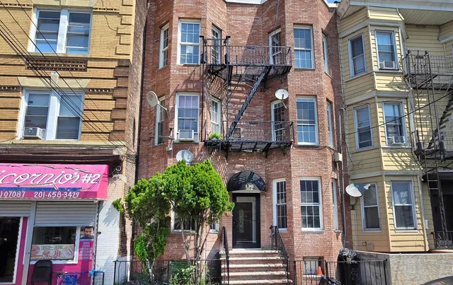 a front view of a multi story building with a yard