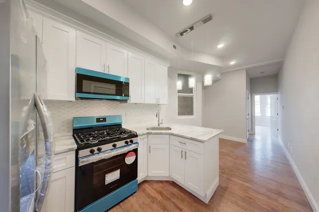 a kitchen with stainless steel appliances granite countertop a stove a sink and a microwave