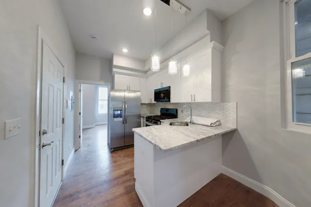 a kitchen with a sink a counter top space stainless steel appliances and cabinets