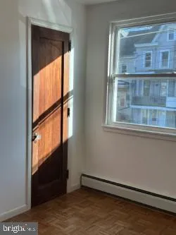 an empty room with closet and windows