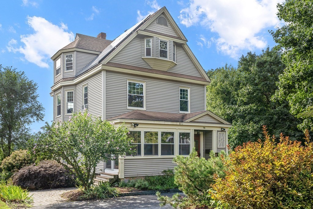 a front view of a house with a yard and trees