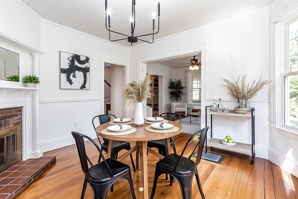 70 Park Avenue Stoneham, MA 02180 - Photo 5 of 36 a dining room with wooden floor a chandelier a wooden table and chairs