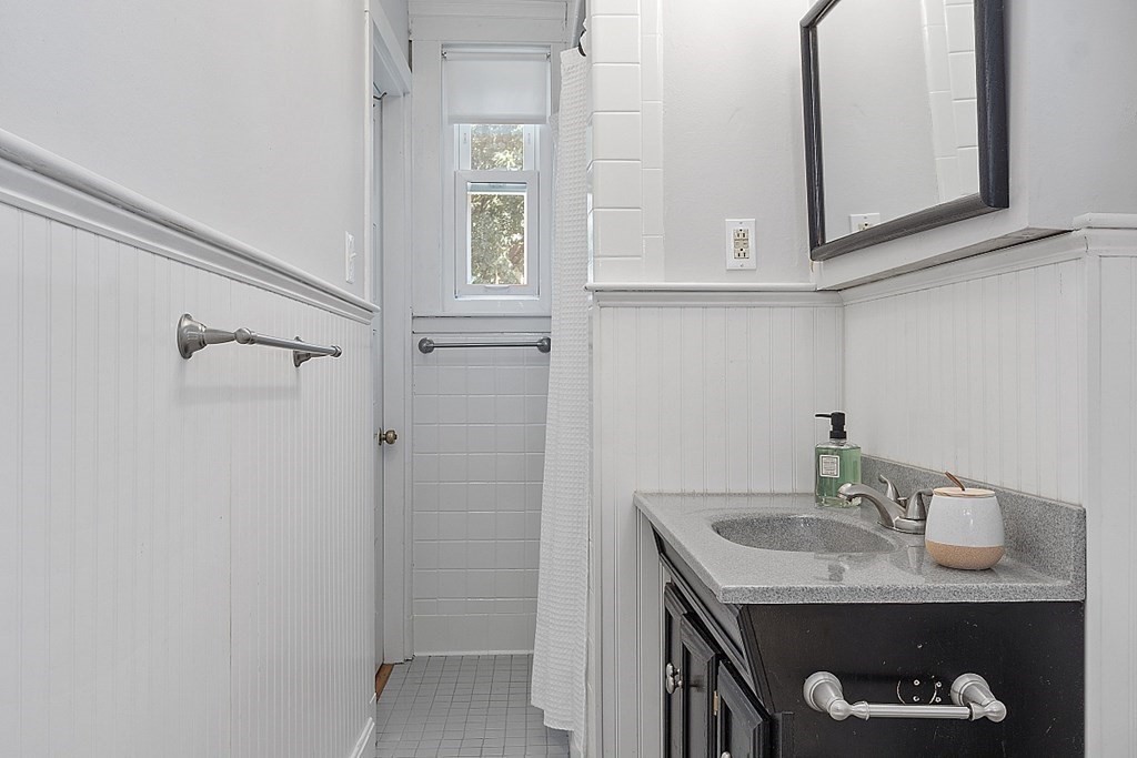 70 Park Avenue Stoneham, MA 02180 - Photo 10 of 36 a bathroom with a granite countertop sink a vanity and a mirror