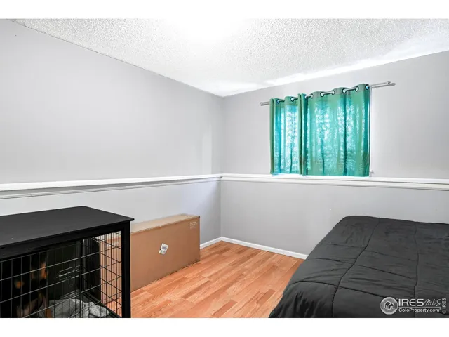 a view of an empty room and window with wooden floor