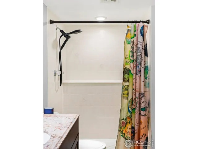 a bathroom with a granite countertop shower and a sink