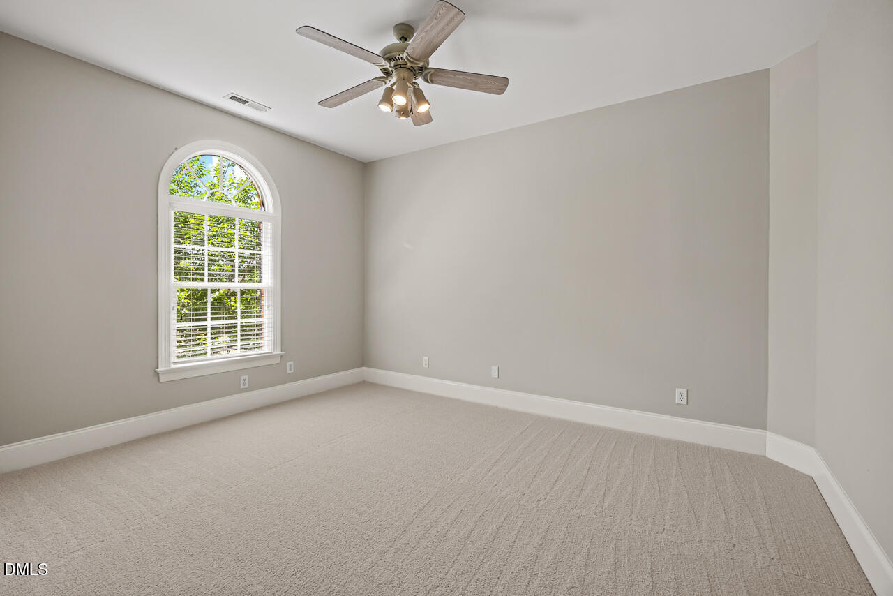 4004 Frontenac Court Apex, NC 27539 - Photo 33 of 61 an empty room with windows and chandelier fan