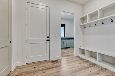 a view of an empty room with closet and wooden floor