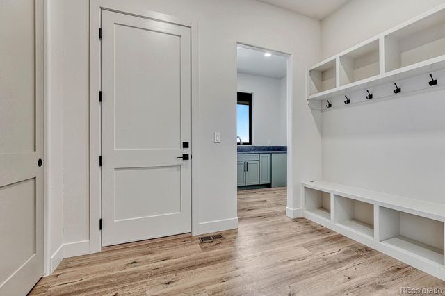 a view of an empty room with closet and wooden floor