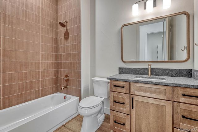 a bathroom with a granite countertop toilet a sink and bathtub