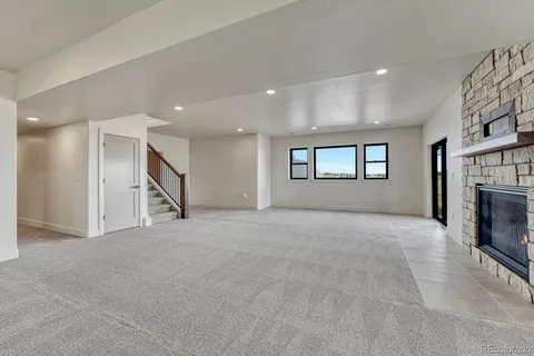 a view of an empty room with a fireplace and a window