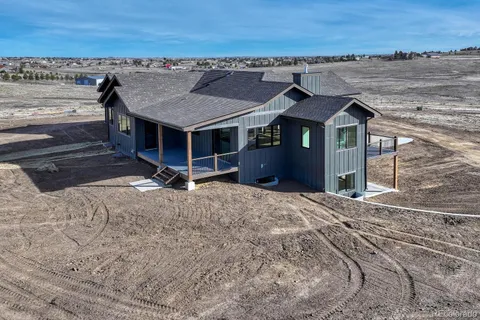 a view of a house with wooden fence and a yard