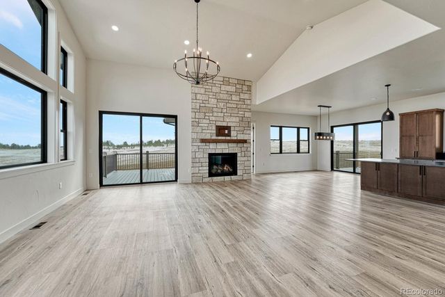 an empty room with wooden floor fireplace and windows