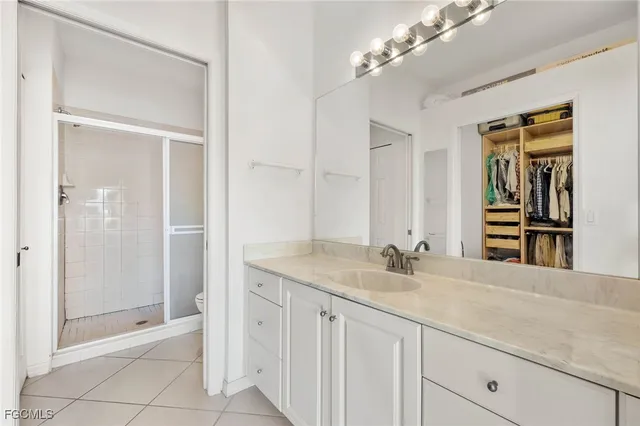 a bathroom with a granite countertop sink a mirror and shower