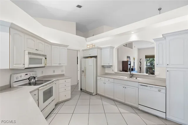 a kitchen with white cabinets stainless steel appliances and sink